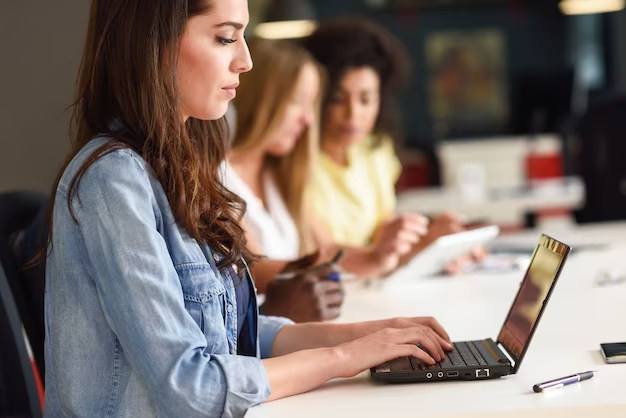 Mujer estudiando en un salón con una laptop