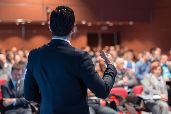 Hombre dando una conferencia corporativa a un grupo de personas